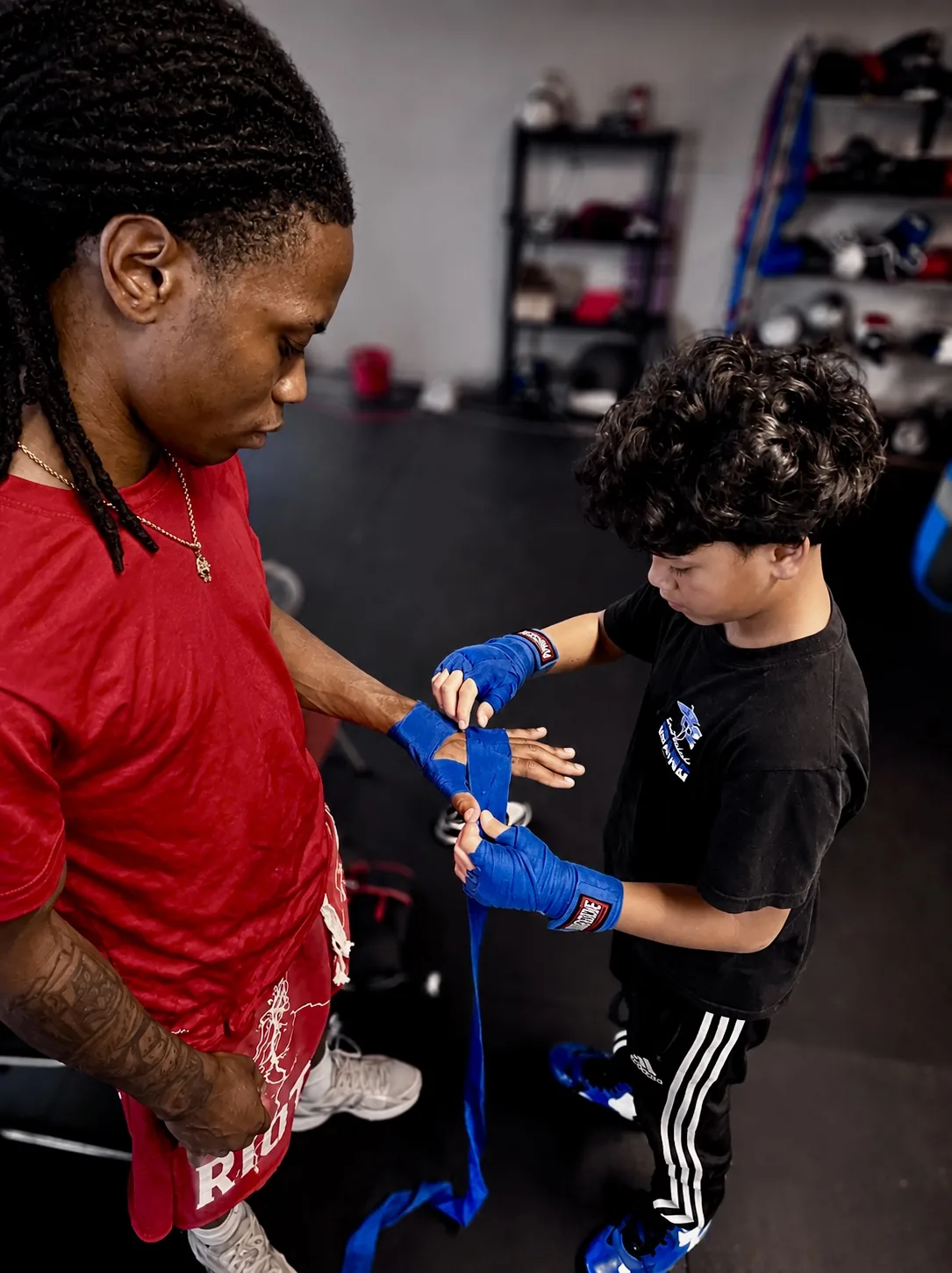 An older boxer wrapping a young athlete's hands at Saint Michaels Boxing Club